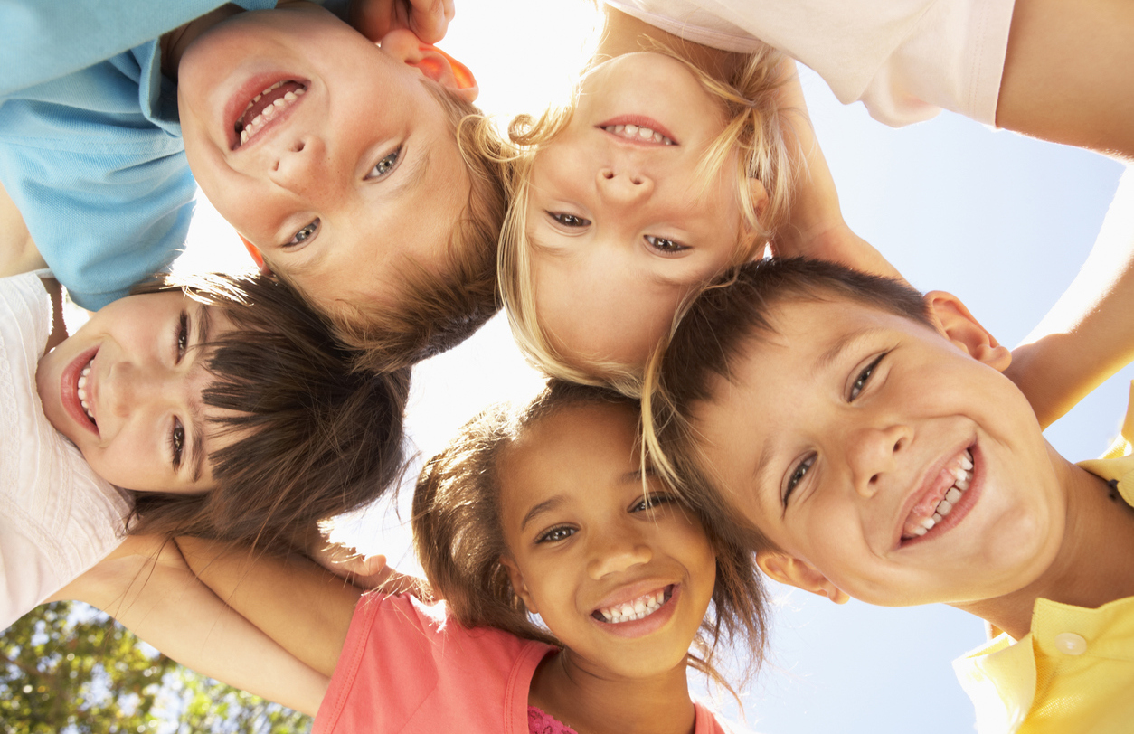 Group Of Children Looking Down Into Camera Smiling